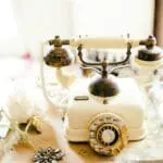 A vintage telephone booth with a sign saying 'Leave your message here!'