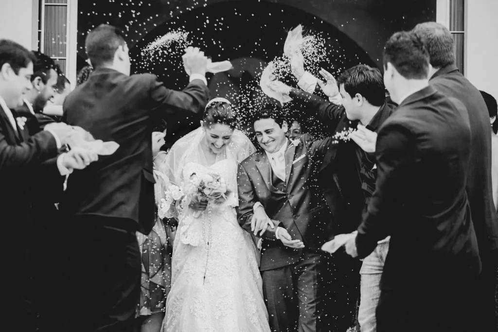 A couple exits church to a rice shower by guests