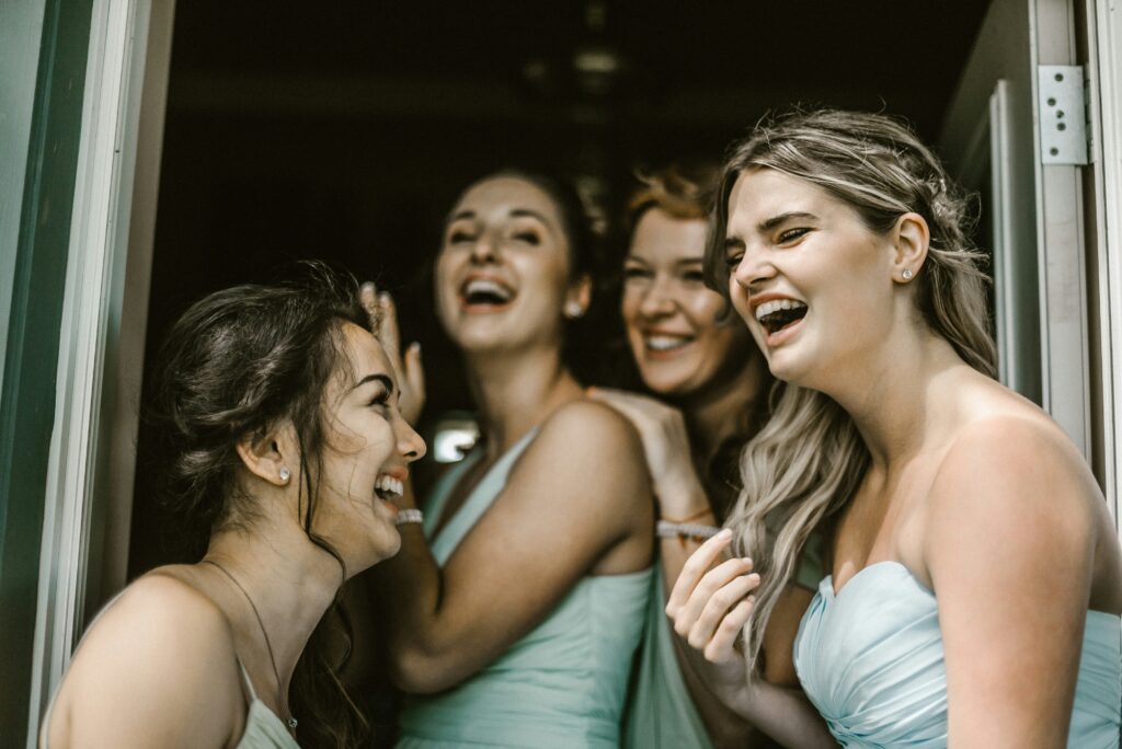 A group of bridesmaids, led by the maid of honor, raising glasses in a celebratory toast.