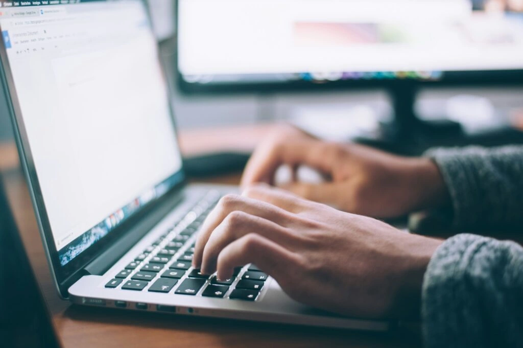 person typing wedding speech on laptop