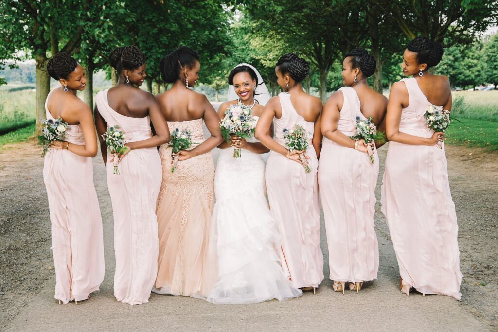A group of bridesmaids, each wearing a unique yet cohesive dress style, posing together with the maid of honor, showcasing her ability to coordinate a stylish and cohesive bridal party look.