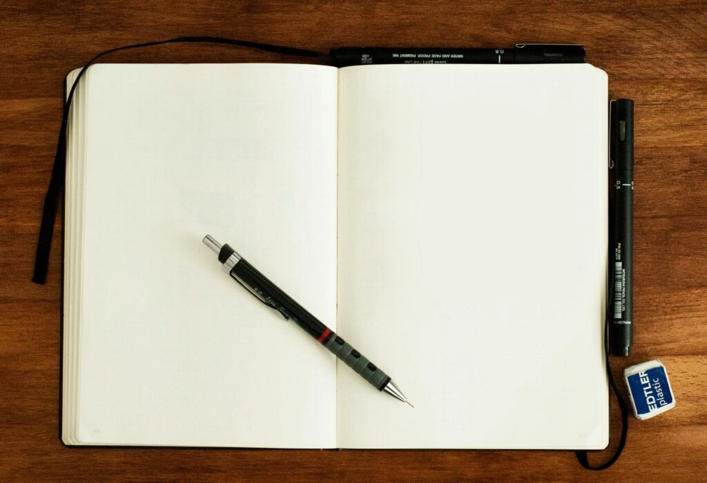 empty notebook and pencils on top of it