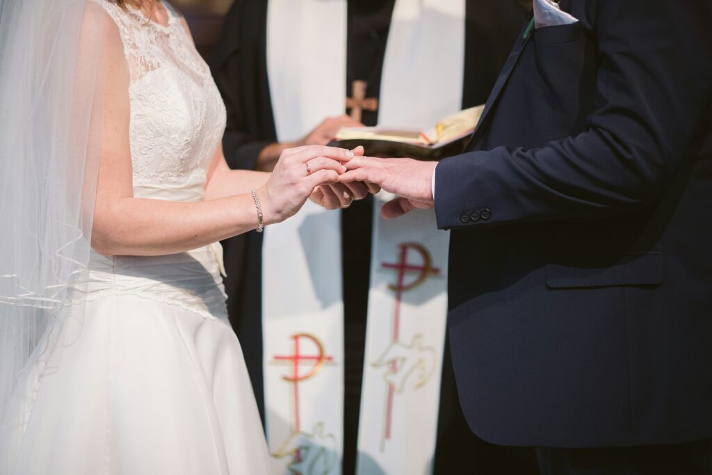 A couple exchanging vows during their wedding ceremony, surrounded by ...