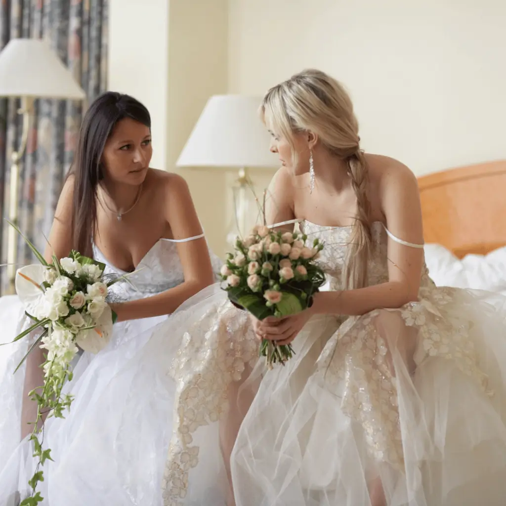 bride and her sister sitting on the bed next to each other